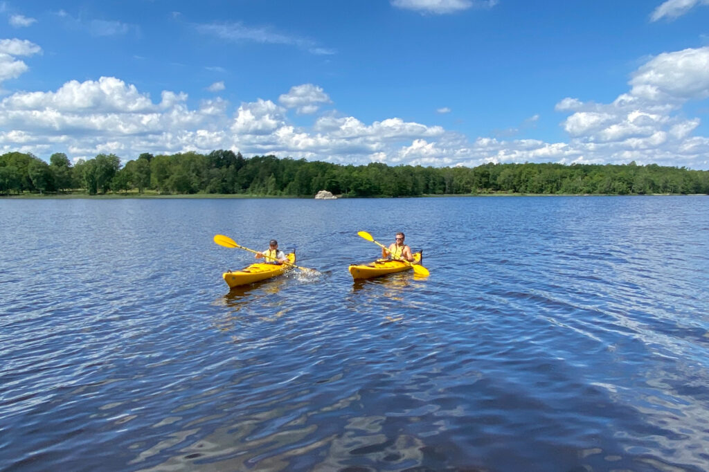 Patrik Widell och hans son paddlar gula kajaker på sjön Åsnen i småland